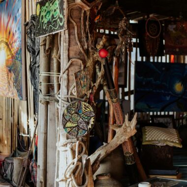 A creatively decorated rustic shack featuring wooden crafts and vibrant art pieces.